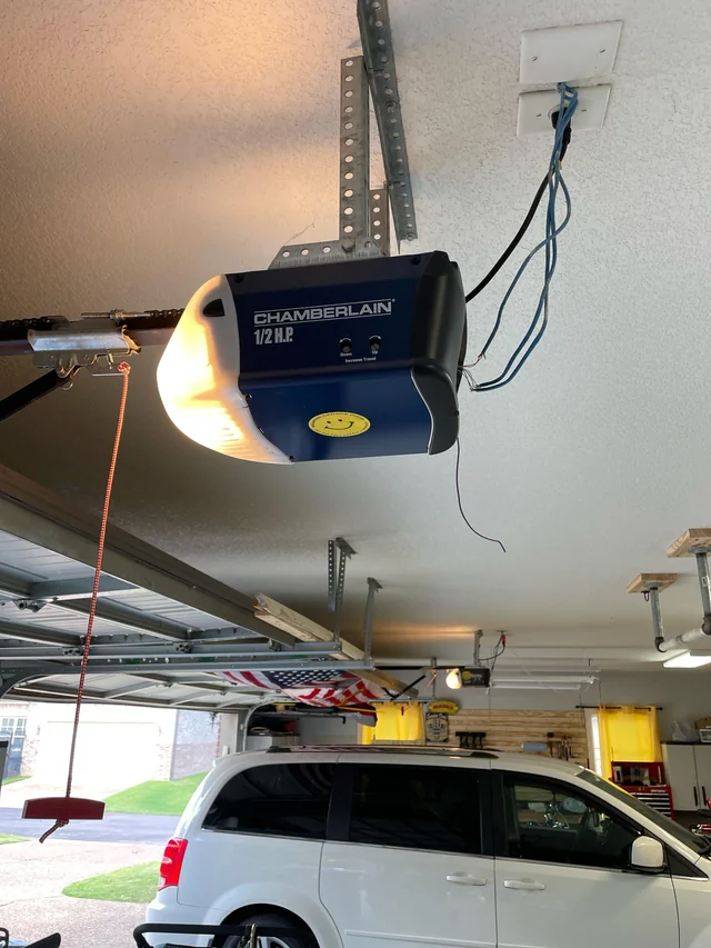 Technician inspecting garage door sensors in Andover MA